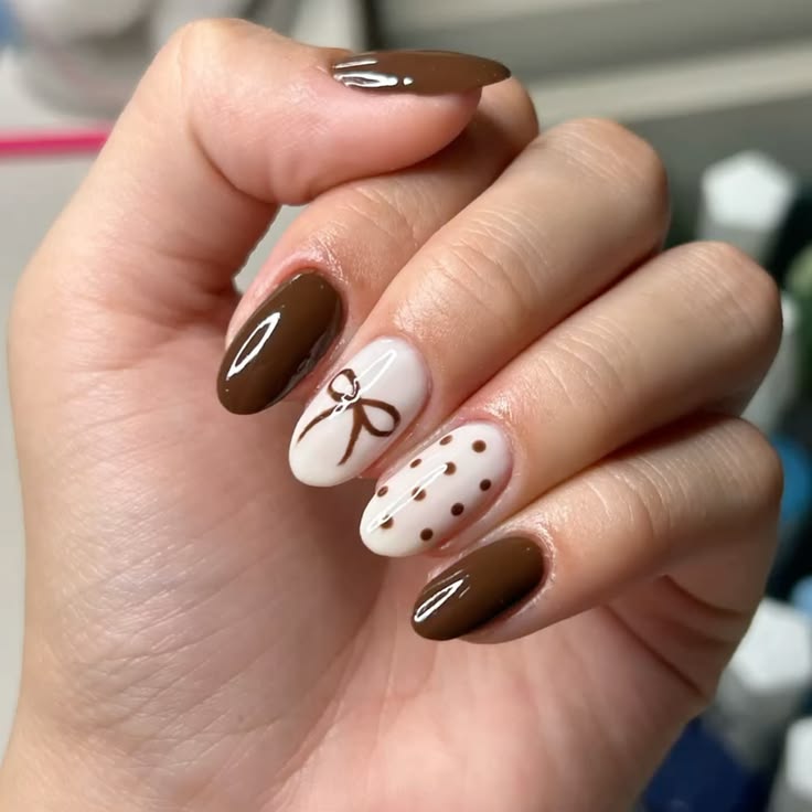 Brown nails shaped into a soft almond, detailed with polka d