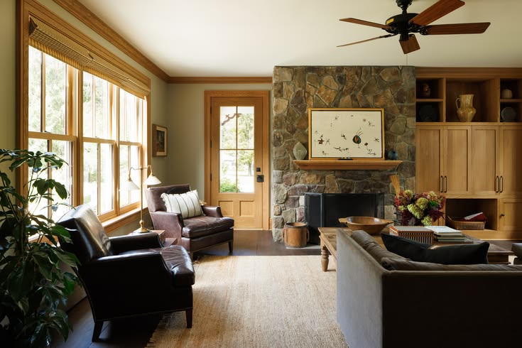 Custom white oak built-ins frame a natural stone fireplace, 