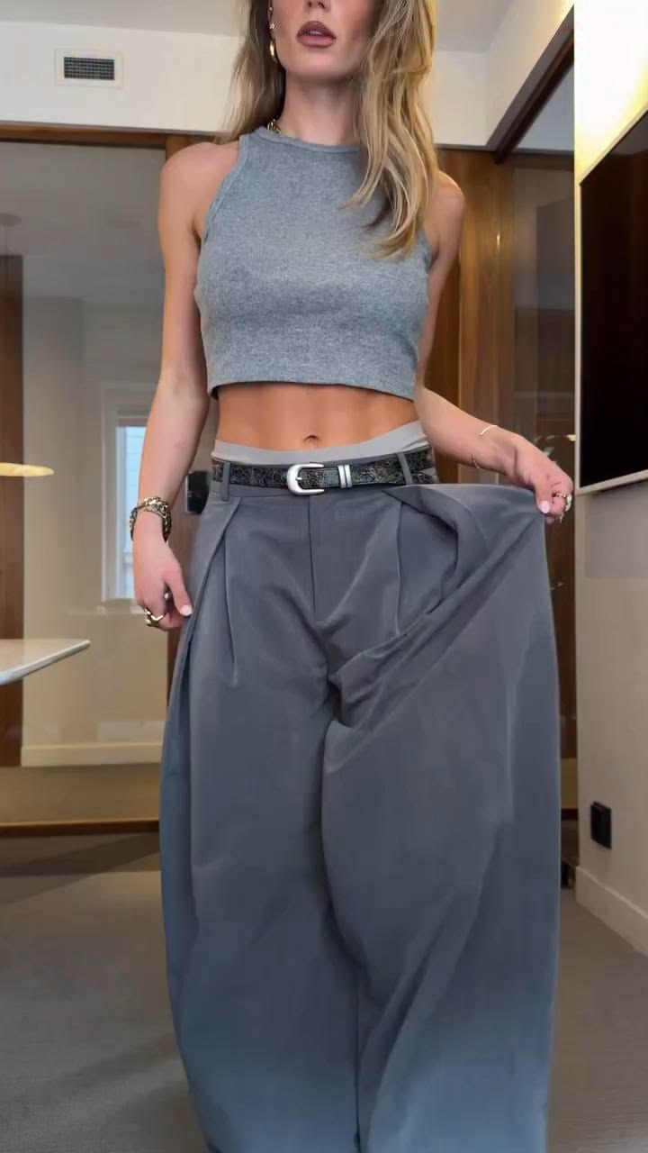 The tailored high-rise waist features sharp front pleats tha